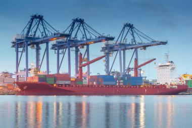 cargo ship in sea port at sunset