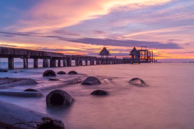 Wooded bridge in the port and sunset clipart