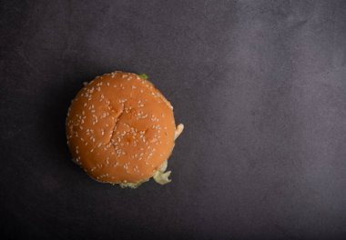 Siyah arka planda hamburger ve susamlı çörek.