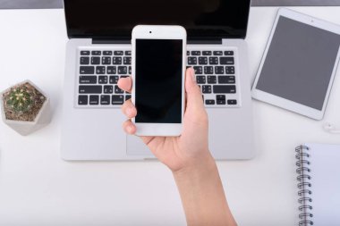 Akıllı telefonu tut ve çalışma masasına dokun