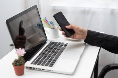Çalışma masasında el ele tutuşan akıllı telefon