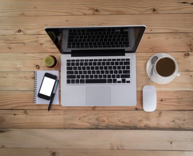 Ahşap ofis resepsiyon masa laptop, kahve, kağıt ve kalem. Kopya alanı ile üstten görünüm.