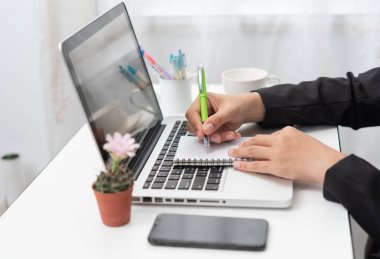 Holding ve office çalışma alanı diğer malzemeleri ve kahve fincanı ile yanındaki boş defterini yazma eller, yakın çekim. Kopya alanı