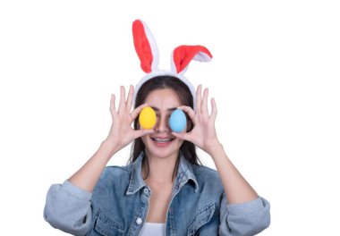 Elinde iki yumurta tutan tavşan şapkalı bir kadın. Yumurtalar sarı ve mavi.