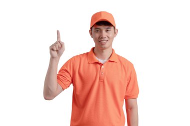 A man in an orange shirt is pointing up with his finger. He is smiling and he is giving a thumbs up