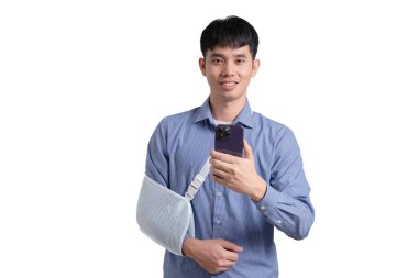 A man with a cast on his arm is holding a cell phone. He is smiling and he is happy clipart