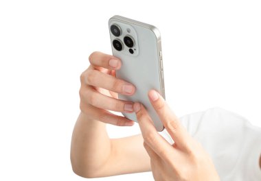 Bir kişi bir telefon tutuyor ve ona bakıyor. Telefon beyaz bir Smartphone. Kişi ekrana odaklanmış görünüyor, muhtemelen bir iletiyi kontrol ediyor ya da internete takılıyor.