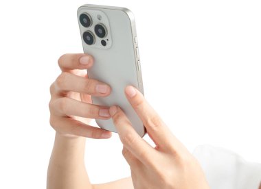 Bir kişi beyaz bir iPhone tutuyor ve ekrana bakıyor. Modern teknoloji kavramı ve akıllı telefon gibi cihazlarla bağlı kalmanın önemi