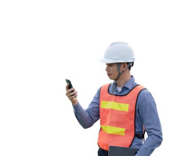 Güvenlik yeleği giymiş bir adam cep telefonuna bakıyor. Tedbir ve sorumluluk kavramı, çünkü adam telefonunu kullanırken çelik yelek giyiyor.