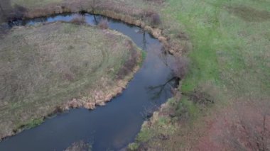 Kırsalda, doğada dolambaçlı bir nehrin manzarası. Ina Nehri, Polonya.