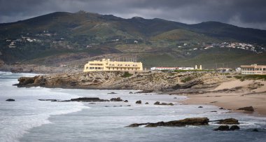 Uzakta Rocky Coastline ve Dağları olan plaj - Praia da Crismina, Cascais Portugal