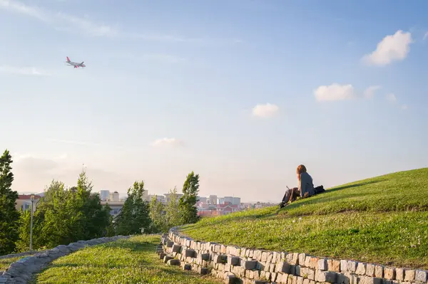  Hillside 'da Uçağı Şehrin Üzerinden İzleyen Kişi