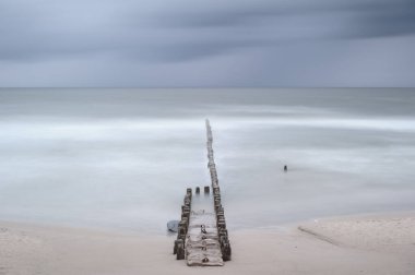 Okyanustaki Uzun Ahşap İskele. Martılar ve dramatik bir gökyüzü.