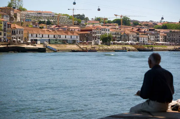 Portekiz, Porto 'daki Douro Nehri kıyısında Cityscape' li bir adam.