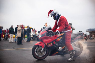 Santa Claus on Motorcycle with Smoke at Christmas Event clipart