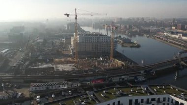 Nehir kıyısında yeni apartmanlar ve şehir inşaatı, Puslu Sabah Işığı. Szczecin Polonya.
