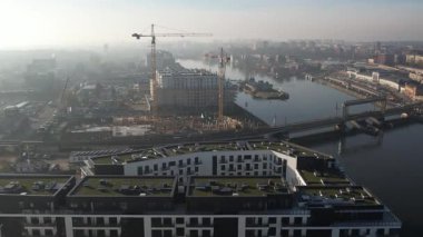 Nehir kıyısında yeni apartmanlar ve şehir inşaatı, Puslu Sabah Işığı. Szczecin Polonya.