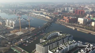 Nehir kıyısında yeni apartmanlar ve şehir inşaatı, Puslu Sabah Işığı. Szczecin Polonya.