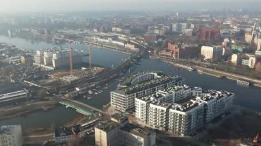 Nehir kıyısında yeni apartmanlar ve şehir inşaatı, Puslu Sabah Işığı. Szczecin Polonya.