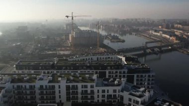 Nehir kıyısında yeni apartmanlar ve şehir inşaatı, Puslu Sabah Işığı. Szczecin Polonya.