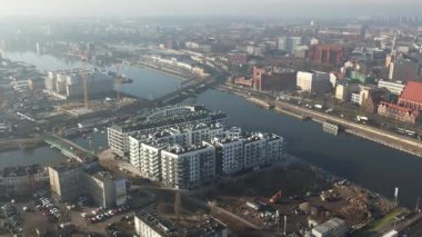 Nehir kıyısında yeni apartmanlar ve şehir inşaatı, Puslu Sabah Işığı. Szczecin Polonya.
