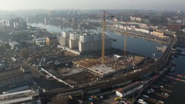 Nehir kıyısında yeni apartmanlar ve şehir inşaatı, Puslu Sabah Işığı. Szczecin Polonya.