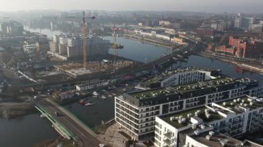 Nehir kıyısında yeni apartmanlar ve şehir inşaatı, Puslu Sabah Işığı. Szczecin Polonya.