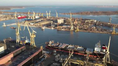 Tersane Hava Görüntüsü: Günbatımında Vinçler, Gemiler ve Endüstriyel Sahne.