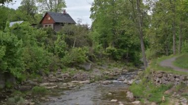 Nehir kenarındaki Cottage 'lı Idyllic Kırsal Sahnesi