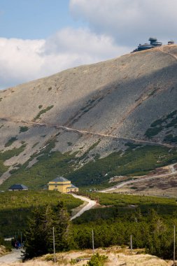 Sniezka tepesi manzarası ve dolambaçlı dağ yolu ile Dom Slaski dağ sığınağı, Karkonosze Ulusal Parkı, Polonya.