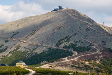 Sniezka tepesi manzarası ve dolambaçlı dağ yolu ile Dom Slaski dağ sığınağı, Karkonosze Ulusal Parkı, Polonya.