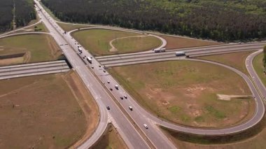 Yüksek açılı insansız hava aracı birden fazla şeritli ve üstgeçitli geniş bir otoyol kavşağını yakalıyor. Geniş yol ağı geniş çam ormanları ve açık çim alanlarıyla çevrilidir..