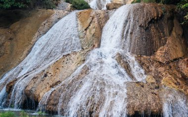 Dağ nehrinde harika bir şelale. Macera ve seyahat konsepti. Doğa arkaplanı.
