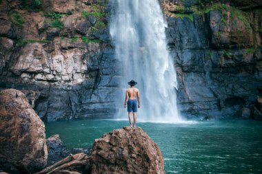 Genç adam dağlarda bir şelalede