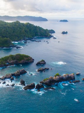 Okyanus dalgalarının kayalık kıyıya çarpmasının insansız hava görüntüsü. Uçurum görünümü