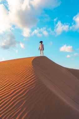 Çöl safarisi sırasında Dubai 'nin kumullarında yürüyen genç adamlar. Dubai 'nin çölünde yürüyen bir adam