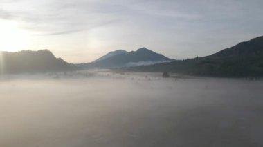 Bali 'de gündoğumunda Batur Dağı' nın çarpıcı hava manzarası, Batur volkanı üzerinde sisli bir sabah, Endonezya doğası, Bali 'de yürüyüş ve turizm. Yüksek kalite 4k görüntü