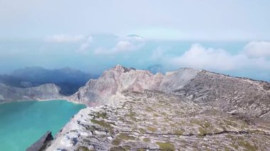 Güneş doğarken sis ve dumanla çevrili güzel bir sülfür gölü olan Ijen volkanı, Kawah İjen, Java, Endonezya.