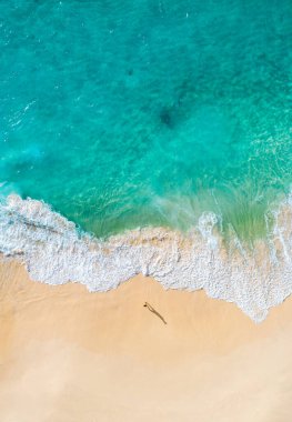 Turkuaz dalgalı tropikal plaj manzarası.