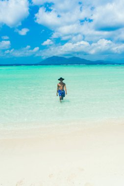 Kumsaldaki mutlu genç adam. yaz tatili konsepti