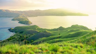 Dağları ve okyanusu olan yeşil adanın panoramik hava manzarası. Gili Lawa Adası, Komodo Ulusal Parkı, Endonezya 'da güzel bir gün batımı..