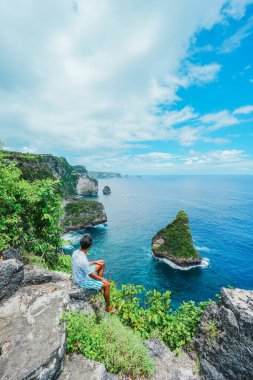 Gezgin, Nusa Penida, Bali, Endonezya 'daki okyanusa, kayalara ve turkuaz plajlara bak. yaz arkaplanı ve yaz tatili kavramı.