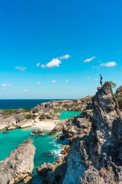 İnsan Atlantik Okyanusu 'nun güzel manzarasının tadını çıkarırken bir kayanın üzerinde duruyor kaya oluşumları ve turkuaz denizle. yaz arkaplanı ve yaz