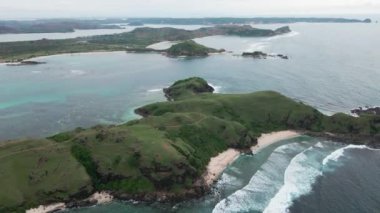 Merese Hill, Lombok, Endonezya 'da güneşli bir günde okyanus manzarası ve yeşil kayalık tepeler..