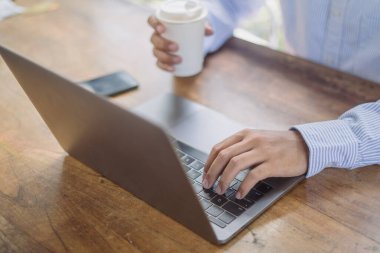 close up of a male hand typing on laptop keyboard working on a laptop in the office, concept of business and finance