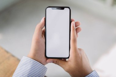 Cep telefonu boş beyaz ekran mockup.man el ele mesajlaşması ofisteki masada cep telefonu kullanıyor.Reklam için arka plan boş yer. İş insanları pazarlama ve teknoloji ile iletişime geçiyor