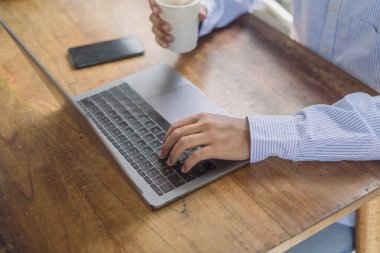 İşadamı internette dizüstü bilgisayarda çalışıyor, internette sörf yapıyor, modern ofiste ağ kuruyor, yakınlaşıyor. İşadamı el yazısı ob laptop bilgisayar klavyesi ofis masasında