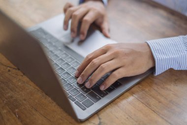 İş adamı dizüstü bilgisayarda klavye üzerinde ofis masasında, online çalışma, internette sörf, uzak iş, uzaktan çalışma konsepti