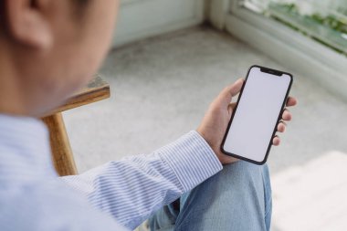 Model adam el ele tutuşuyor. Kafede beyaz ekranlı akıllı telefon kullanıyor. Mobil uygulama tasarımı ve reklamı, online pazarlama.