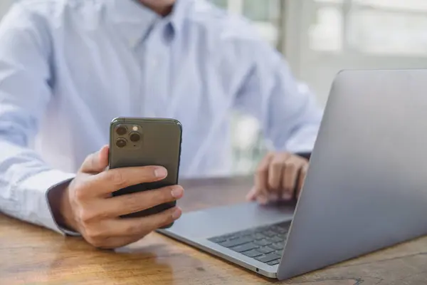Ofiste çalışan bilgisayar ve telefon kullanan bir işadamı.